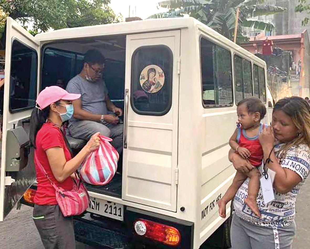 Een medewerker van de redemptoristenkerk in het district Baclaran in Manilla deelt hulpgoederen uit.