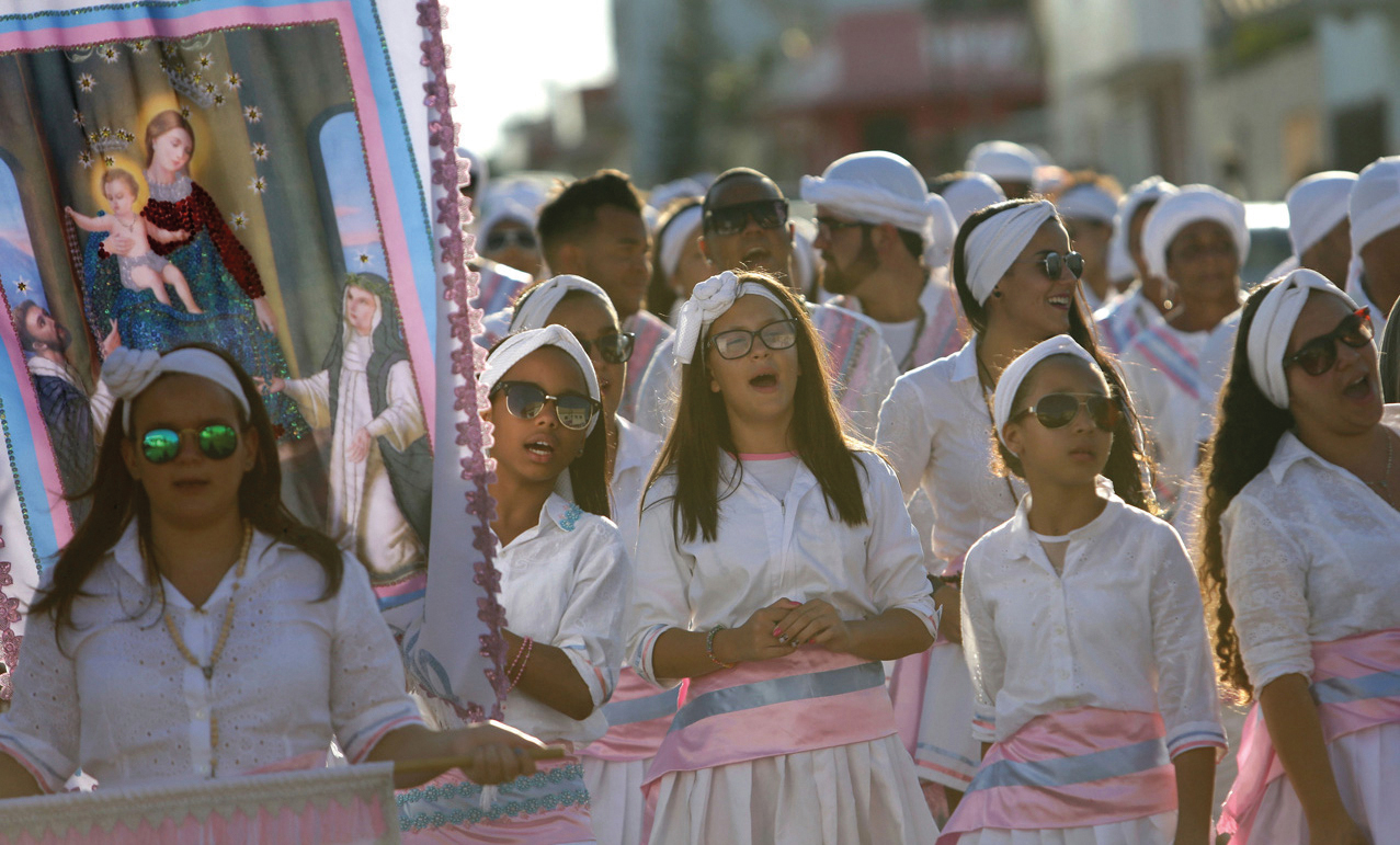 Een groep meisjes gaat zingend mee in de jaarlijkse ‘Congada’ processie in Catalao (9 oktober 2016) met het beeld van OLV van de Rozenkrans.